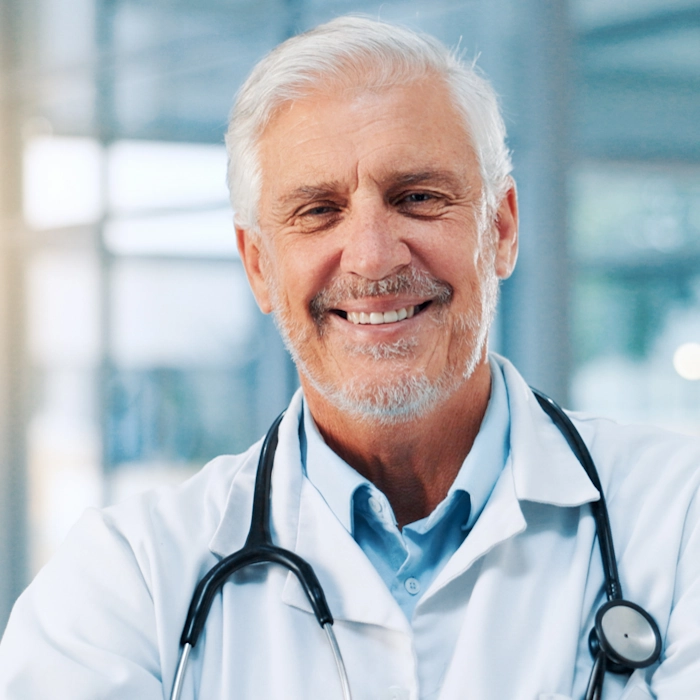 Portrait of a happy older male physician with a stethoscope around his neck